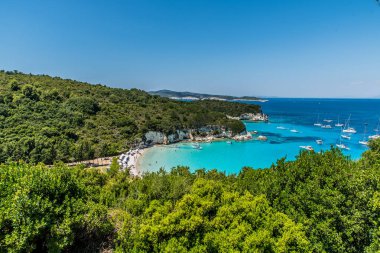 A crystal clear waters from the small wooden pier in the Voutoumi beach in the island of Antipaxoi, Ionian islands, Greece