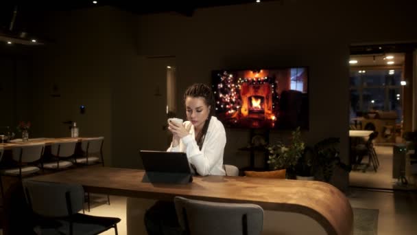 Een meisje met dreadlocks in een wit shirt dat tijdens een online les een digitaal tablet gebruikt, leert van video via een tablet. Online leerconcept. — Stockvideo