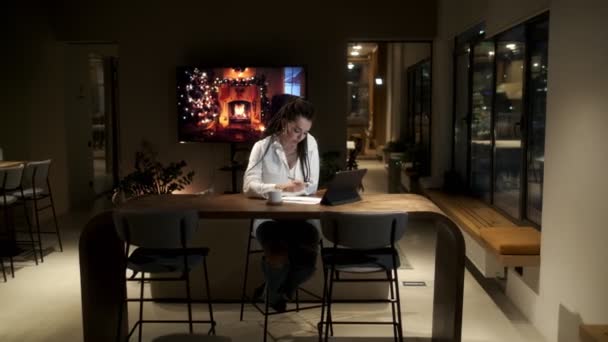 Uma menina com dreadlocks em uma camisa branca usando um tablet digital em uma lição on-line aprende a escrever uma lição. Conceito de aprendizagem online. — Vídeo de Stock