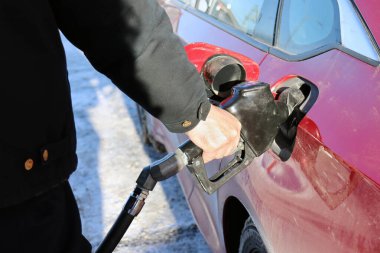 Benzin istasyonunda benzin pompalayan adam.