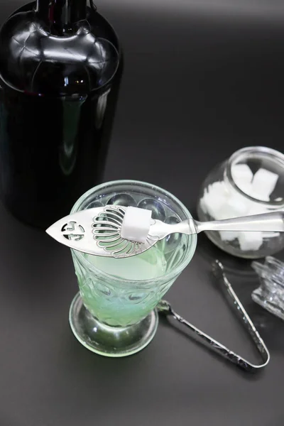 Absinthe kaşık ve şeker küpüyle çizilmiş eski bir bardak apsent. 