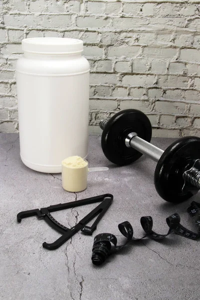 Vücut yağlı kalibre, mezura ve bir kepçe protein tozu..