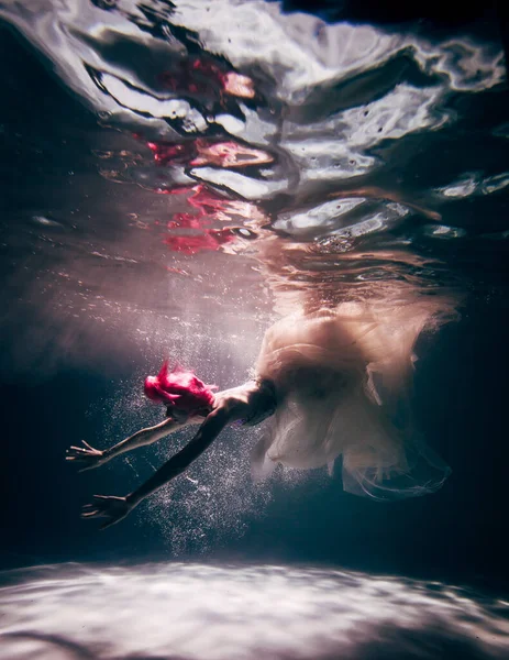 Young woman underwater in a beautiful dress underwater shooting