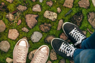 İki kişinin spor ayakkabıları, üst manzara.