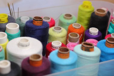 Dikiş dikmek için renkli ipliklerle dolu bir kutu. Dikiş, dikiş ve terzilik konsepti. Kumaş ve tekstil endüstrisi