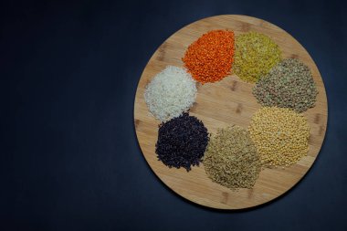 Siyah arka planda Legumes. (Sarı mercimek, yeşil mercimek, kırmızı mercimek, bulgur, pirinç, siyah pirinç, buğday)
