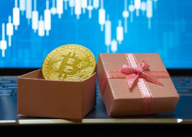 Bitcoin BTC cryptocurrency in a gift box with a stock trading background, gold coin as a symbol of electronic virtual money for web banking and international network payment clipart