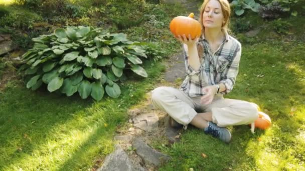 Gyönyörű nő a kertben a sütőtök — Stock videók