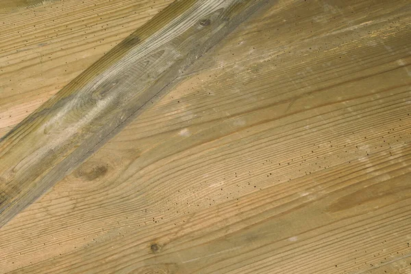 Eski tahtalar solucanlar tarafından hasar görmüş, yakından görülmüş, kapılar siyaha boyanmış, kalaslar birleşmiş.