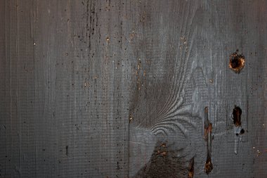 Eski tahtalar solucanlar tarafından hasar görmüş, yakından görülmüş, kapılar siyaha boyanmış, kalaslar birleşmiş.