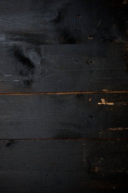 Eski tahtalar solucanlar tarafından hasar görmüş, yakından görülmüş, kapılar siyaha boyanmış, kalaslar birleşmiş.