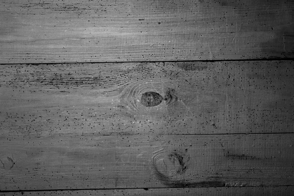 Eski tahtalar solucanlar tarafından hasar görmüş, yakından görülmüş, kapılar siyaha boyanmış, kalaslar birleşmiş.