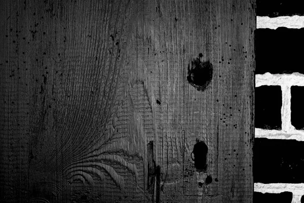 Eski tahtalar solucanlar tarafından hasar görmüş, yakından görülmüş, kapılar siyaha boyanmış, kalaslar birleşmiş.