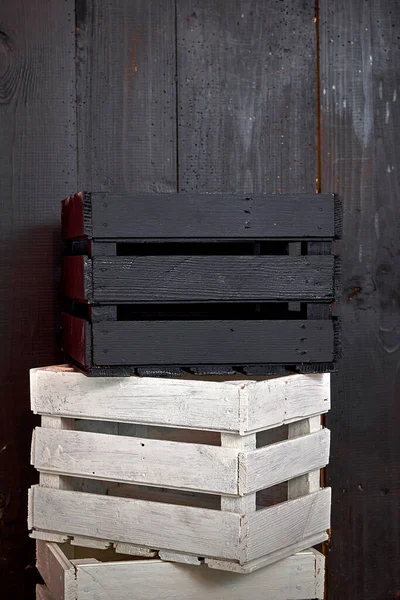 Eski tahtalar solucanlar tarafından hasar görmüş, yakından görülmüş, kapılar siyaha boyanmış, kalaslar birleştirilmiş, ahşap kutu.