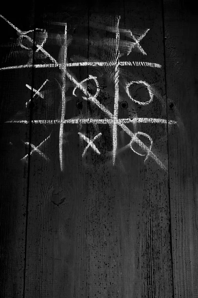 Eski tahtalar solucanlar tarafından hasar görmüş, yakından görülmüş, kapılar siyaha boyanmış, kalaslar birleşmiş.