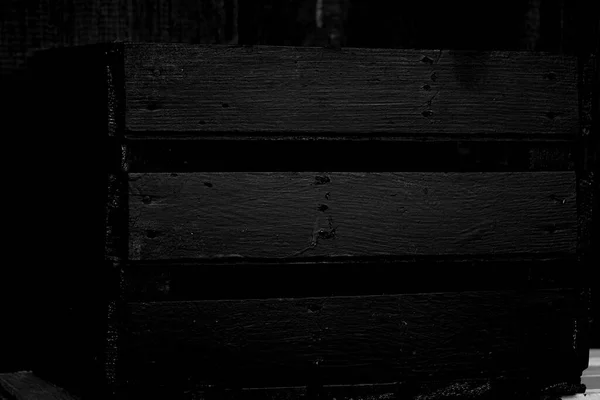 Eski tahtalar solucanlar tarafından hasar görmüş, yakından görülmüş, kapılar siyaha boyanmış, kalaslar birleşmiş.