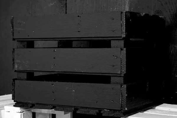 Eski tahtalar solucanlar tarafından hasar görmüş, yakından görülmüş, kapılar siyaha boyanmış, kalaslar birleşmiş.