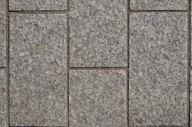 Rectangular gray cubes, equal sizes, straight, cut stones, edges on top, structure of split cubes, gaps between cubes with dark sand