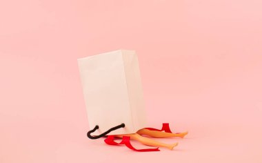 Alışveriş çantasından yapılmış kız bacaklarından yapılmış yaratıcı bir manzara. Minimalist moda ya da tarz kavramı. Boşluğu kopyala.