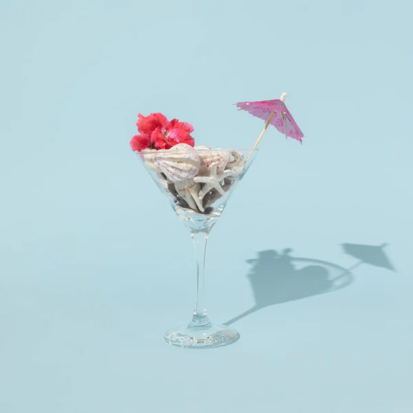 Szklanka Martini Muszelkami Piękny Czerwony Kwiat Parasol Koktajlowy Pastelowym Niebieskim — Zdjęcie stockowe