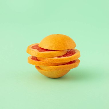 Pastel arka planda greyfurt dilimlerinden yapılmış yaratıcı bir fikir. Yaz organik tropikal meyve kavramı.