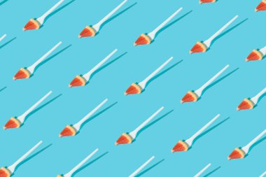 Kalıplar narenciye dilimli, çatallı ve güneşli mavi arkaplanlı. Yaratıcı sağlıklı atıştırmalık, yiyecek, meyve veya vejetaryen konsepti. Yaz trendi gölgeleri. Pop sanat sahnesi.