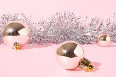 Pembe arka planda gümüş renginde deformasyonlardan oluşan Noel kompozisyonu. Asgari xmas mevsimlik kavramı.