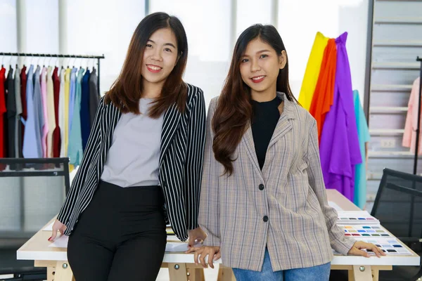 两个年轻漂亮的女设计师和时装店店主站在一起 面带微笑地看着相机 裁缝店里的时尚企业家肖像画 小公司和创业企业的想法 — 图库照片