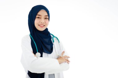 A beautiful, smiling Asian Muslim woman doctor with a good personality poses with self-confidence on a white background.