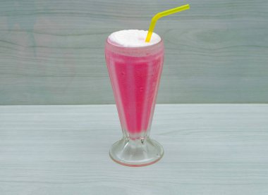 Gri arka planda lezzetli çilekli milkshake bardağı sağlıklı yaz içeceği.