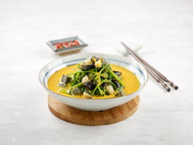 Çin ıspanağı, tuzlu yumurta ve yüzyıllık yumurta, yemek çubuklarıyla birlikte gri arka planda.