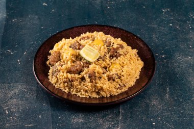 Tabakta baharatlı biftek biryani ve mermer arka planda Hint ve Pakistan yemekleri.