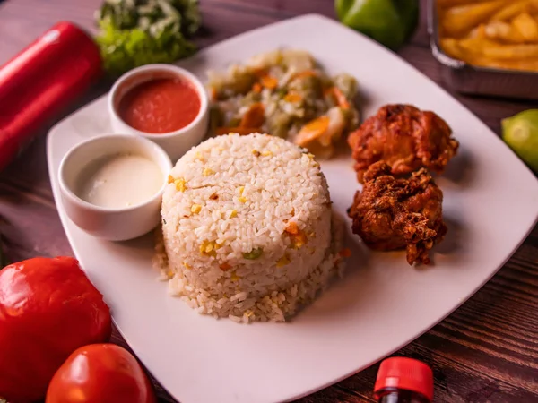 fried rice with fried chicken, drink, with raita, sauce, salad and drink isolated on wooden background top view of korean food