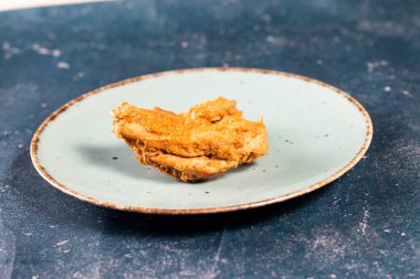 Fast food 'un arka planında izole edilmiş bir tabakta kızarmış tavuk parçası.