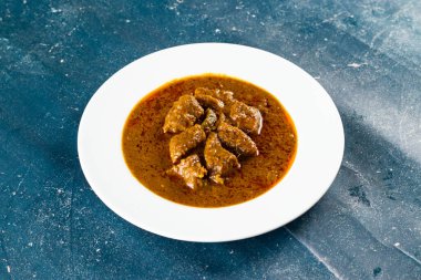 Pakistan ve Hint yemeklerinin arka planında mermer bir tabakta izole edilmiş baharatlı et qorma masala.