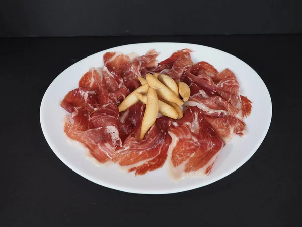 Iberico Ham Met Knoflook Geserveerd Een Schotel Geïsoleerd Donkere Achtergrond — Stockfoto