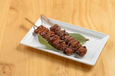 Japon BBQ Kawa kebap çubukları ahşap arka planda beyaz tepside