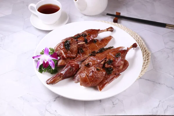 Salted fried Duck in a dish with tea side view on grey background singapore food