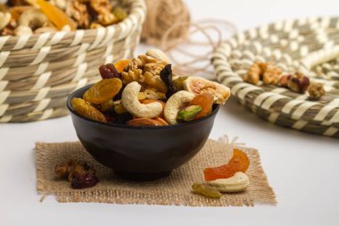 Kuru meyveler, fındıklı badem, ceviz, fıstık, şam fıstığı, kuru üzüm, kuru kayısı, peçete tarafında izole edilmiş, gri arka planda kuru meyveler.