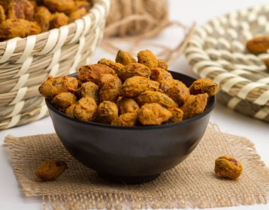 Badem masala, gri arka planda fındıkların peçete tarafında izole edilmiş bir kasede servis edilir.