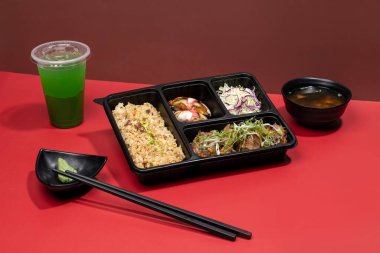 TOFU STEAK PREMIUM BENTO naneli margarita, sos ve çubuklarla Japon fast food 'unun kırmızı arka planında izole edilmiş