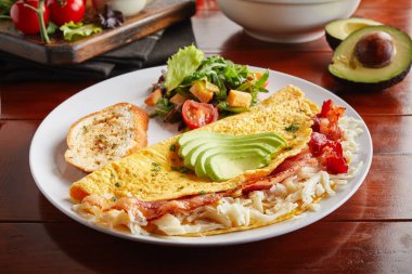 Kaliforniya omlet rulosu ve salatası ahşap arka planda izole edilmiş bir tabakta servis edilir.