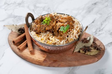Indian spicy Chicken Kali Mirch Biryani (Black Pepper Chicken Biryani) Served in a dish isolated on wooden board side view on grey background
