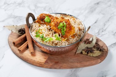 Baharatlı Hint Baharatlı Tavuk Saten Biryani Gri arka planda tahtadan yapılmış bir tabakta servis edilir.