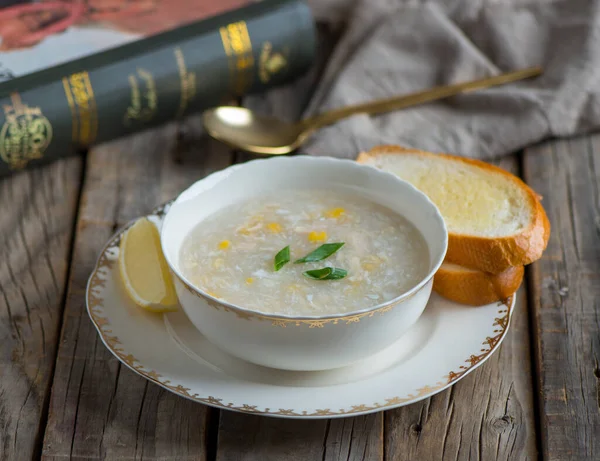 chicken corn soup with garlic bread served in a bowl isolated on wooden background side view of soup