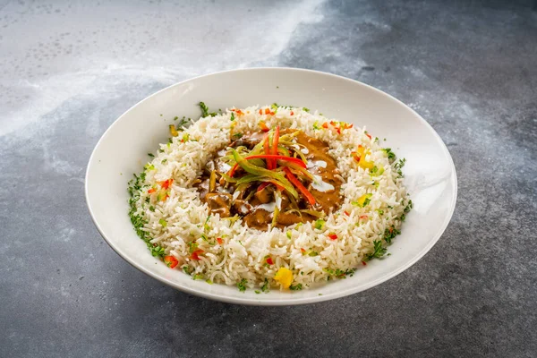 beef stroganoff with buttered rice served in a dish isolated on dark background side view food