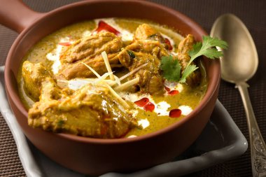 Korma tavuğu koyu arka planda izole bir şekilde servis edilir.