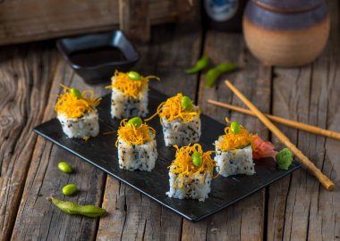 NATSUKI suşi rulo veya natzuki ahşap arka planda izole edilmiş bir kesme tahtasında servis edilir suşi rulo görünümü