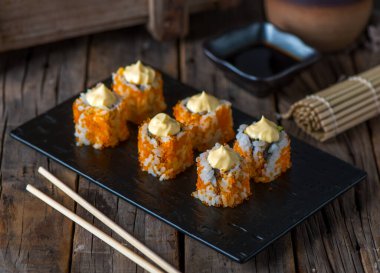 CALIFORNIA suşi rulosu ahşap arka planda izole edilmiş suşi rulosu üzerinde servis edilir.