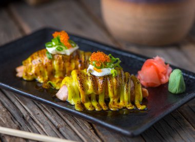 Somon nigiri, Nigiri 'nin ahşap arka planda izole edilmiş bir tabakta servis edilir.